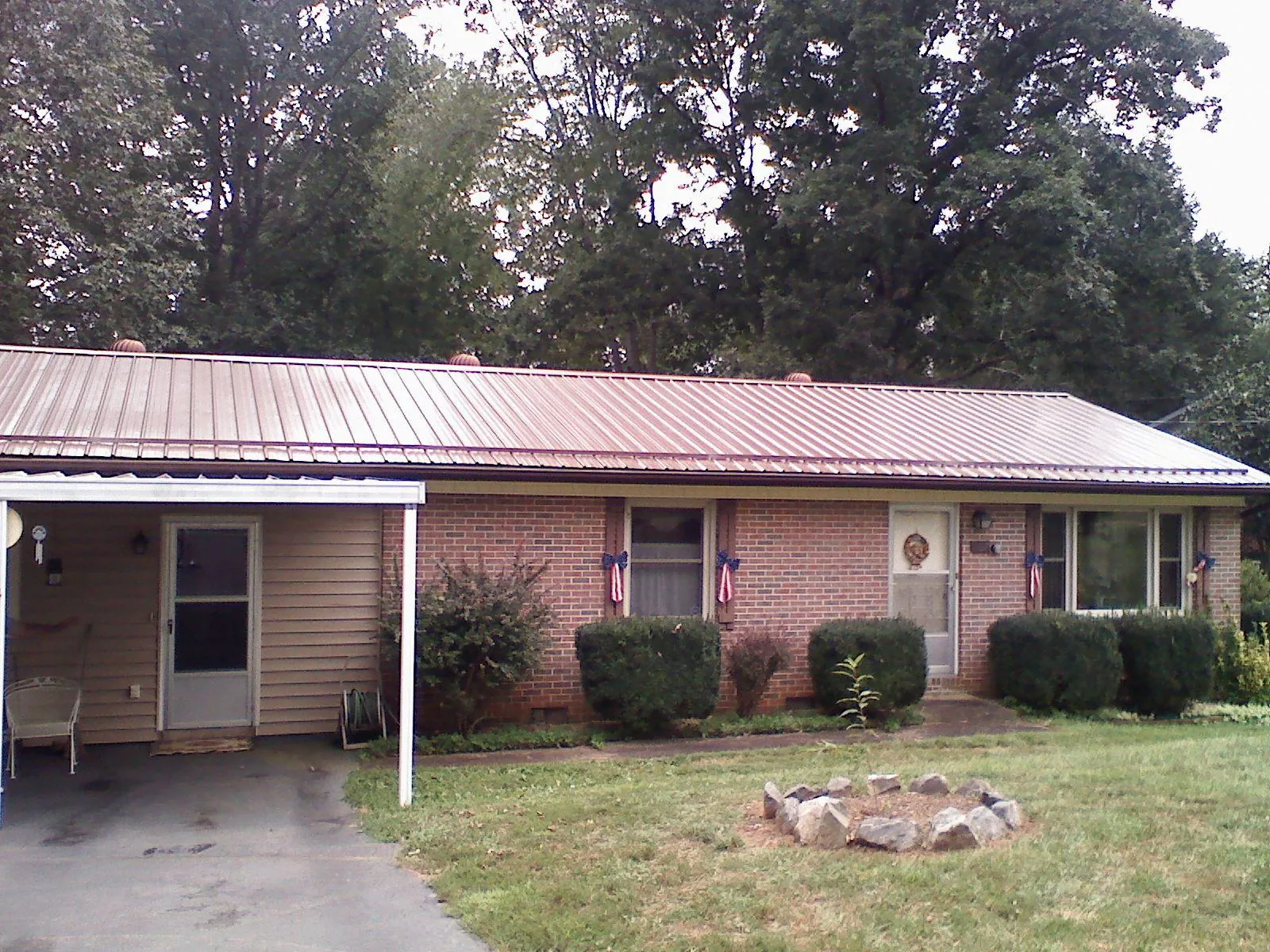 Bronze metal roof and carport on a brick ranch home — Roof Repair work by our crew in Winchester